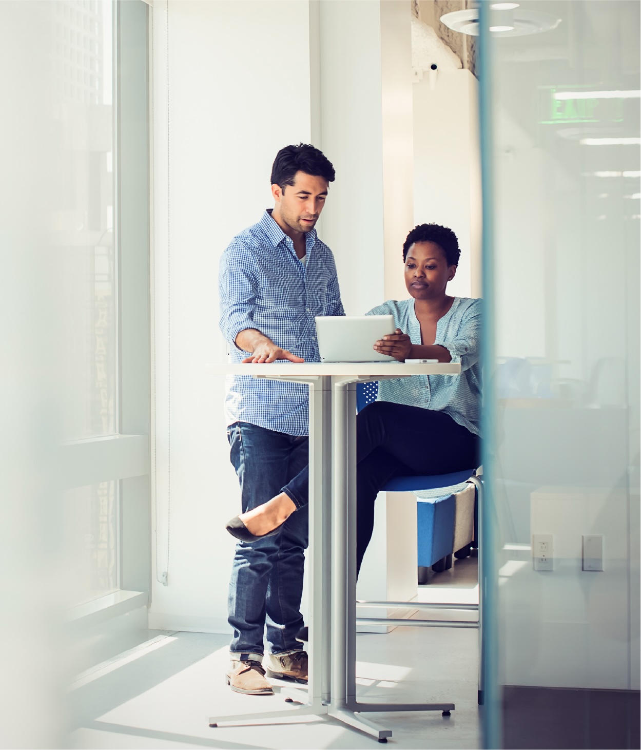 Two coworkers examining data on a tablet mobile device.